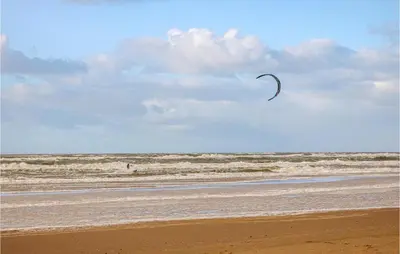 a person is flying a kite on the beach at Pet Friendly Home In Egmond Aan Zee in Egmond aan Zee