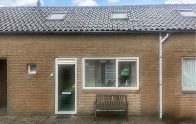 a brick house with a bench in front of a window at Pet Friendly Home In Egmond Aan Zee in Egmond aan Zee