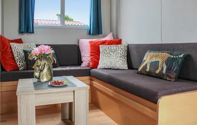 a living room with a couch with pillows and a table at Huis Nr 2 in Woubrugge
