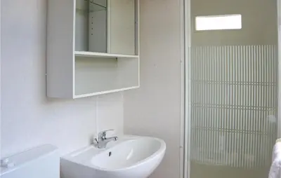 a bathroom with a sink and a mirror and a shower at Huis Nr 5 in Woubrugge