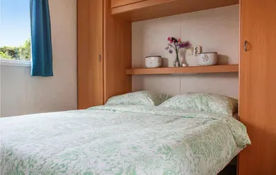 a bedroom with a bed with a green comforter and a window at Huis Nr 5 in Woubrugge
