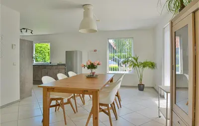 a dining room with a wooden table and white chairs at Horsterhuis in Zeewolde