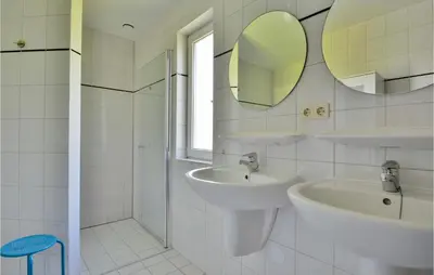 a white bathroom with two sinks and a mirror at Horsterhuis in Zeewolde