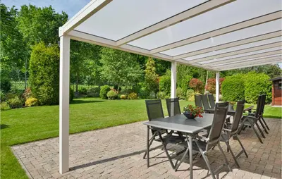 a white pergola on a patio with a table and chairs at Horsterhuis in Zeewolde