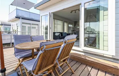 a patio with a wooden table and chairs on a deck at Aqualiving in Aalsmeer