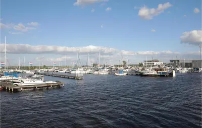 a group of boats docked at a dock in the water at Aqualiving in Aalsmeer