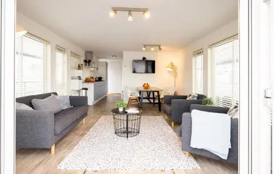 a living room with two couches and a table at Aqualiving in Aalsmeer
