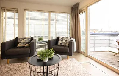 a living room with two chairs and a table at Aqualiving in Aalsmeer