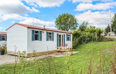 a white cottage with a picnic table in a yard at Huis Nr 1 in Woubrugge