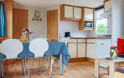 a kitchen and living room with a table and chairs at Huis Nr 1 in Woubrugge
