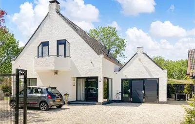 a white house with a car parked in the driveway at Gorgeous Home In Bunschoten-Spakenb in Bunschoten