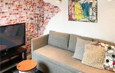 a living room with a couch and a brick wall at Gorgeous Home In Bunschoten-Spakenb in Bunschoten