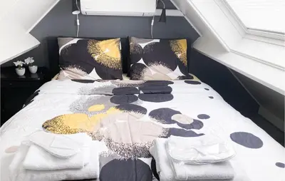a bed with a comforter and pillows on it at Gorgeous Home In Bunschoten-Spakenb in Bunschoten