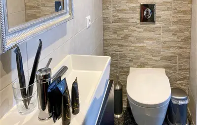 a bathroom with a white sink and a toilet at Gorgeous Home In Bunschoten-Spakenb in Bunschoten