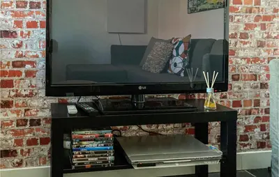 a living room with a couch and a television on a table at Gorgeous Home In Bunschoten-Spakenb in Bunschoten