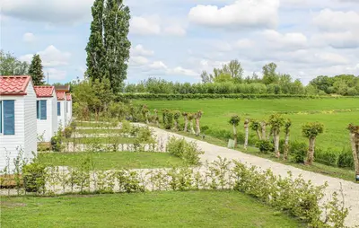 a garden with trees and a white building at Huis Nr 4 in Woubrugge
