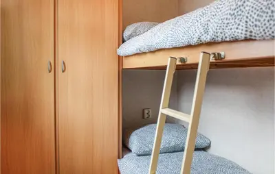 a bunk bed with a ladder next to a bunk bed at Huis Nr 3 in Woubrugge