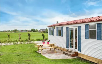 a small white cottage with a picnic table in the yard at Huis Nr 3 in Woubrugge
