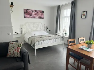 a bedroom with a bed and a couch and a table at B&B Zunderdorp in Amsterdam