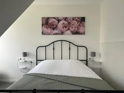 a bedroom with a bed with a picture of roses at B&B Zunderdorp in Amsterdam
