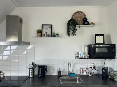 a kitchen counter with a sink and a microwave at B&B Zunderdorp in Amsterdam