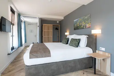 a bedroom with a large bed and a tv at Hof van Holland Hotel in Edam