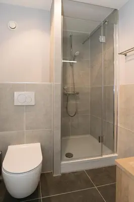 a bathroom with a glass shower with a toilet at Hof van Holland Hotel in Edam