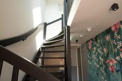 a staircase with a floral mural on the wall at Hof van Holland Hotel in Edam