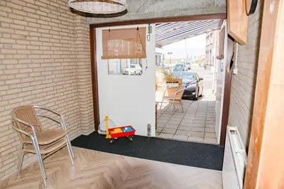a front door with a chair and a childs toy at Beachhouse Anna, 1 minute walk to the beach and centre of Katwijk, Free private parking next to the house ! in Katwijk aan Zee