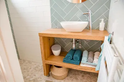 a bathroom with a wooden vanity with a sink at Beachhouse Anna, 1 minute walk to the beach and centre of Katwijk, Free private parking next to the house ! in Katwijk aan Zee