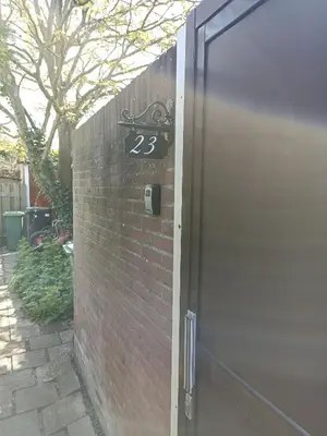 a door with the number on it next to a brick wall at Little Beach Place in Zandvoort