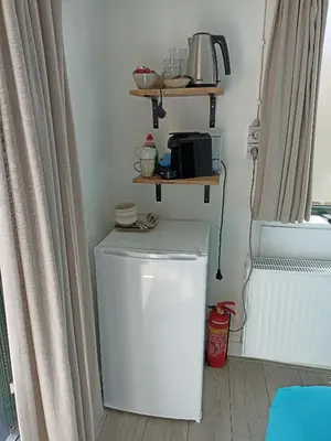 a laundry room with a white washer at Little Beach Place in Zandvoort
