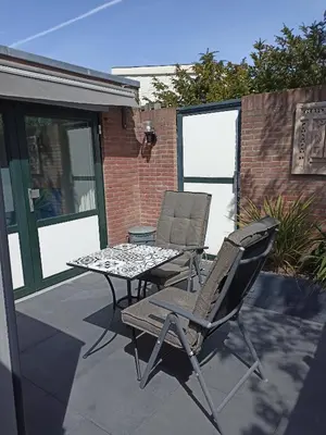two chairs and a table on a patio at Little Beach Place in Zandvoort