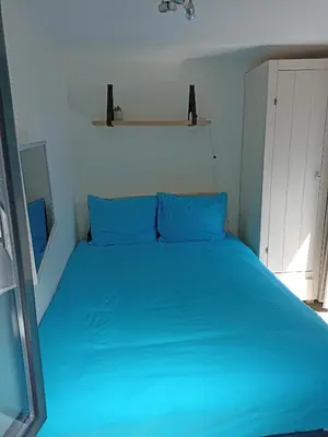 a blue bed with blue pillows in a bedroom at Little Beach Place in Zandvoort