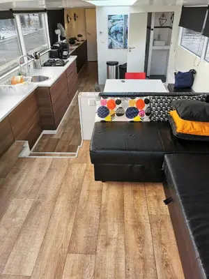a living room with a couch and a kitchen at loft boat in Amsterdam