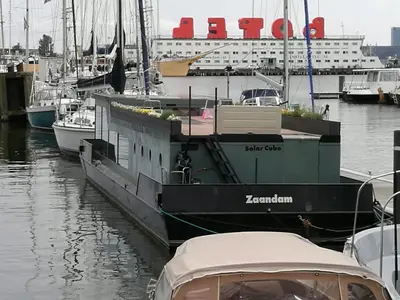 a boat docked at a marina with a cruise ship at loft boat in Amsterdam
