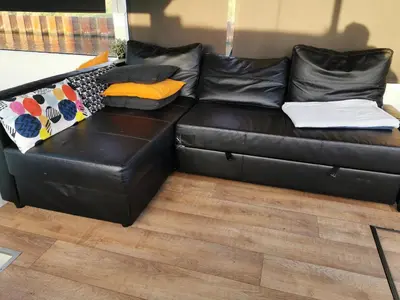 a black leather couch with colorful pillows on it at loft boat in Amsterdam