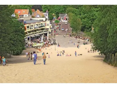 a group of people walking on a beach at Appartement RoMi in Koedijk