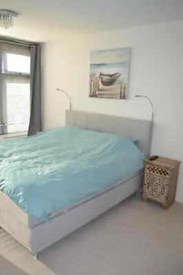 a bedroom with a bed and a painting on the wall at Beachy Chic Zandvoort in Zandvoort