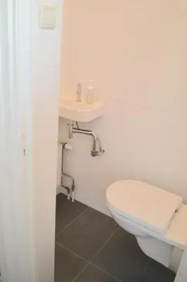 a bathroom with a toilet and a sink at Beachy Chic Zandvoort in Zandvoort