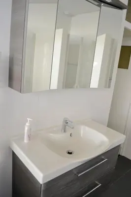 a bathroom with a white sink and a mirror at Beachy Chic Zandvoort in Zandvoort
