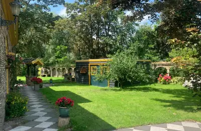a garden with a small shed in the grass at B&B De Hooiberg Edam-Volendam in Edam