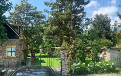 a house with a fence and a garden at B&B De Hooiberg Edam-Volendam in Edam