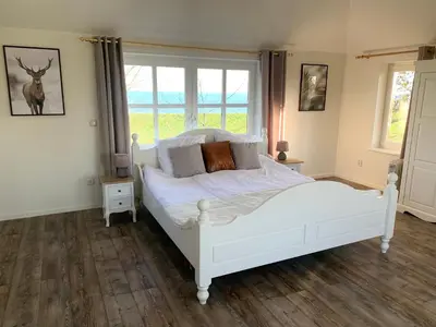 a white bed in a room with a window at B&B De Hooiberg Edam-Volendam in Edam