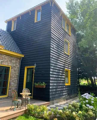 a black house with a table on a deck at B&B De Hooiberg Edam-Volendam in Edam