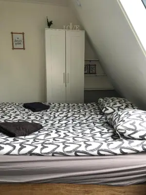 a bedroom with a bed and a white cabinet at Have a nice stay! - Holiday Home de Witte Raaf with garden and hottub in Noordwijk aan Zee