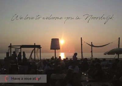 a crowd of people watching a stage with the sunset at Have a nice stay! - Holiday Home de Witte Raaf with garden and hottub in Noordwijk aan Zee