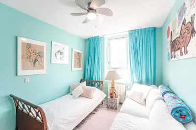 a living room with blue walls and two white couches at Beach Suite Sand in Zandvoort