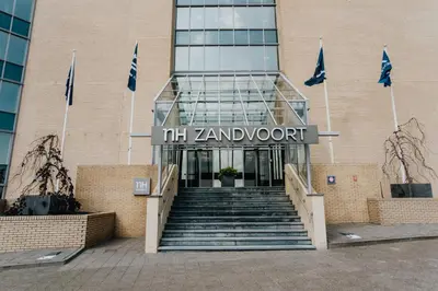 a building with a staircase in front of a building with flags at Beach Suite Sand in Zandvoort