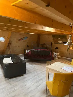 a living room with two beds and a table at De Loft in Zuid-Scharwoude